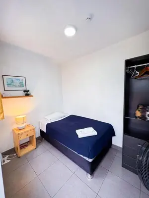 a small bedroom with a bed and a television at Casaroma Hostels in Lima