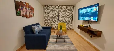 a living room with a blue couch and a tv at Warmisitay H O M E in Lima
