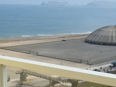 a view of a building next to the beach at Apartment 03 dormitorios San Miguel in Lima