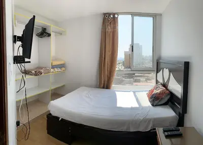 a small room with a bed and a window at Apartment 03 dormitorios San Miguel in Lima