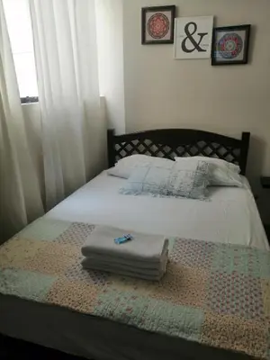 a bed with a quilt and two towels on it at Lopez House in Lima