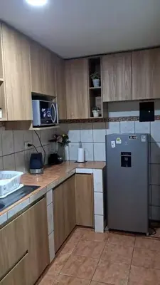 a kitchen with wooden cabinets and a refrigerator at Lopez House in Lima