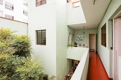 a hallway of a house with white walls and red floors at Charming Miraflores Guesthouse with Terrace Studio Apartment and Private Room in Lima