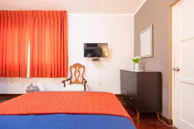 a bedroom with a bed and a television in it at Charming Miraflores Guesthouse with Terrace Studio Apartment and Private Room in Lima