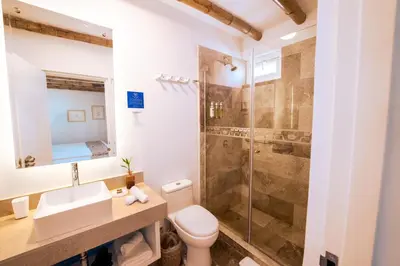 a bathroom with a shower and a toilet and a sink at Atoq Paracas Reserva in Paracas