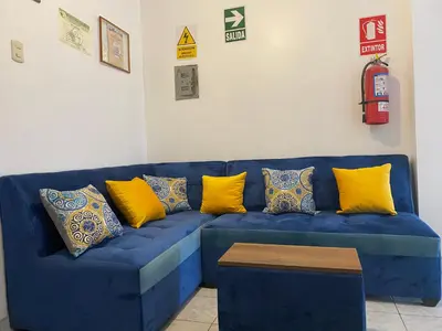 a blue couch with yellow pillows on it at Hostal Venus - Nueva Imagen in Huacho