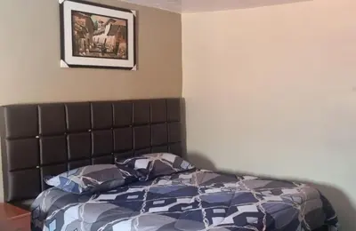 a bedroom with a bed and a picture on the wall at CASA HOSPEDAJE LA FLORIDA in Cusco