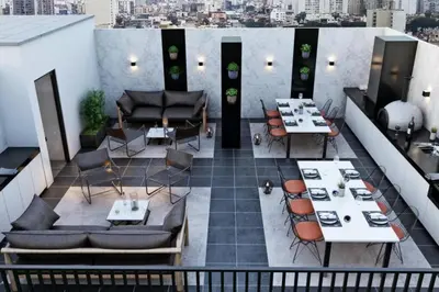 a rooftop patio with tables and chairs on a building at Apartment with incredible view, pool and gym in Lima