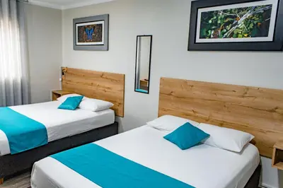 two beds in a hotel room with blue and white at Casa Plaza Bolivar in Quillabamba