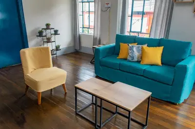 a blue couch and a chair in a living room at Casa Plaza Bolivar in Quillabamba