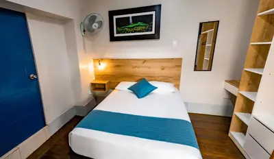a bedroom with a bed with a blue pillow at Casa Plaza Bolivar in Quillabamba