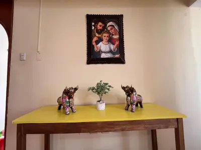 a table with two figurines on it with a picture on the wall at Hotel Perumanta Boutique in Cusco