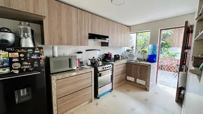 a kitchen with wooden cabinets and a black refrigerator at Casa Verde Jesús María - Zona Residencial in Lima