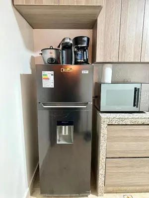 a refrigerator in a kitchen next to a microwave at Casa Verde Jesús María - Zona Residencial in Lima
