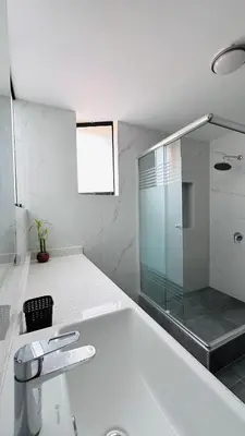 a bathroom with a glass shower and a sink at Casa Verde Jesús María - Zona Residencial in Lima