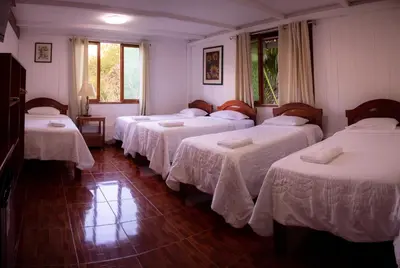 a group of four beds in a room at Albergue Turístico Gstir in Pozuzo