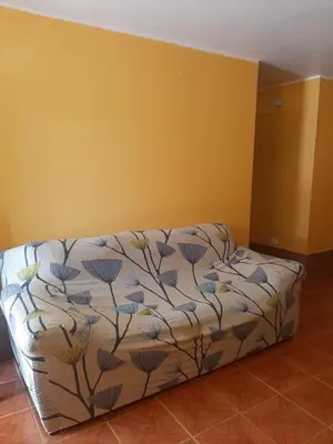 a bed in a room with a yellow wall at Casa La Ruta Pisco in Pisco