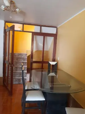 a glass table and a chair in a room at Casa La Ruta Pisco in Pisco