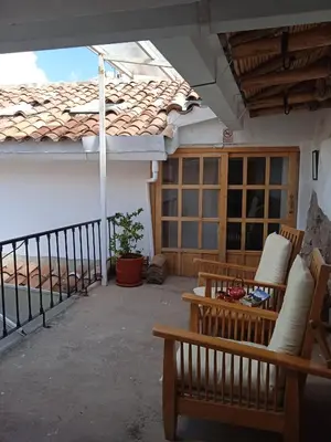 a patio with two benches and a balcony at SAMANA B&B in Cusco