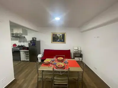 a living room with a table and a red couch at (24)Dpto de estreno en el corazón de Miraflores in Lima