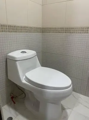 a bathroom with a white toilet in a tiled room at (24)Dpto de estreno en el corazón de Miraflores in Lima