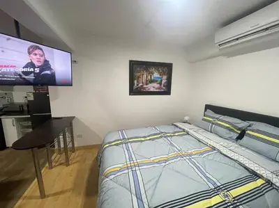 a bedroom with a bed and a flat screen tv at (25) Dpto con inmejorable ubicación en Miraflores in Lima