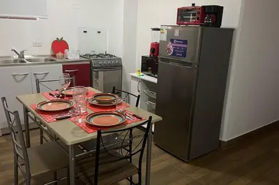 a small kitchen with a table and a refrigerator at (29) Dpto Nuevo y Acogedor Miraflores in Lima