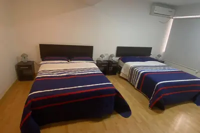 a bedroom with two beds with blue and striped sheets at (29) Dpto Nuevo y Acogedor Miraflores in Lima