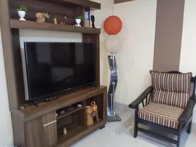 a living room with a television and a chair at La Casita de Gabriel in Cusco