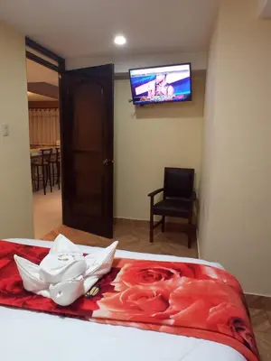 a room with a bed with a tv on the wall at La Casita de Gabriel in Cusco
