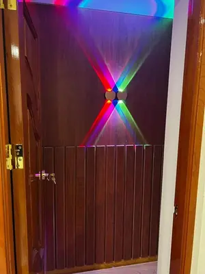 a wooden door with a rainbow colored light on it at Hotel SOGU TOWER in Ayacucho