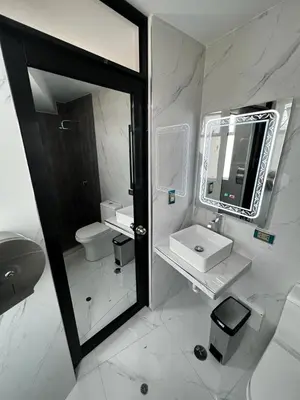 a white bathroom with a sink and a mirror at Hotel SOGU TOWER in Ayacucho
