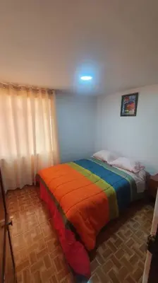 a bedroom with a bed with a colorful blanket at Hospedaje Mary House - En el corazón del Cusco in Cusco