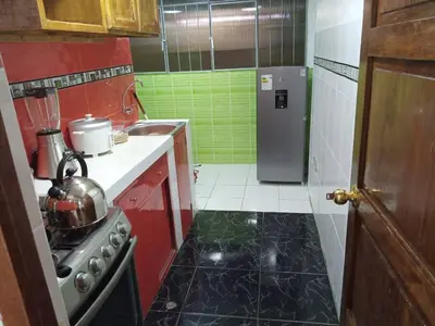 a small kitchen with a stove and a refrigerator at Hospedaje Mary House - En el corazón del Cusco in Cusco