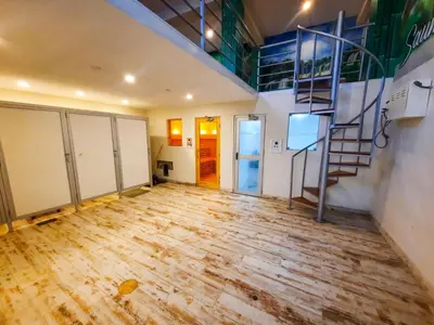 an empty room with a wooden floor and a staircase at Brianny Hotel in Churín