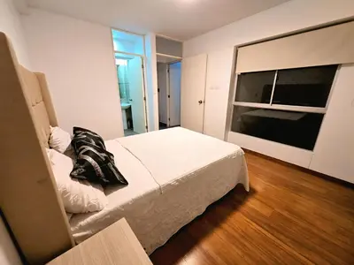 a bedroom with a bed and a large window at Duplex MyM in Lima