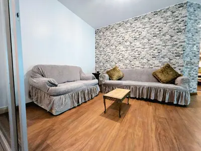 a living room with two couches and a brick wall at Duplex MyM in Lima