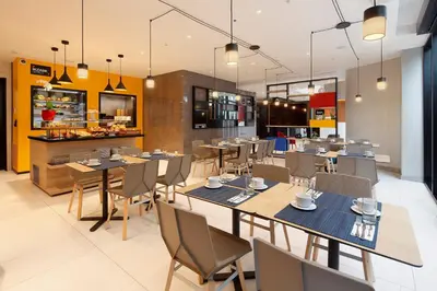a restaurant with tables and chairs and a kitchen at Ikonik Miraflores in Lima