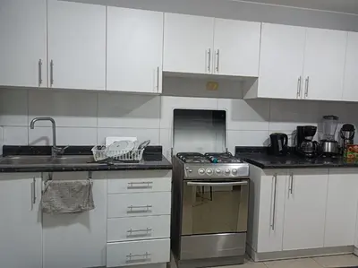 a kitchen with white cabinets and a stove top oven at Miraflores View in Lima