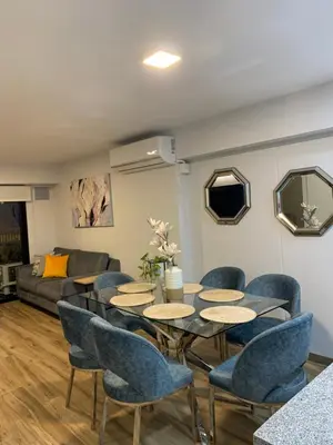 a living room with a table and chairs and a couch at Apartamento en Miraflores con AC in Lima