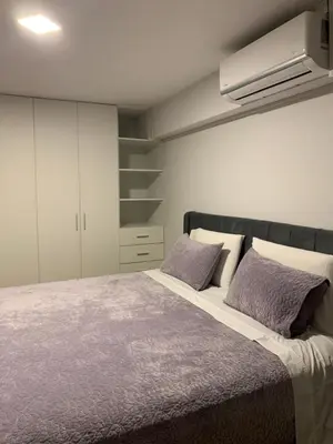 a bedroom with a large bed with two purple pillows at Apartamento en Miraflores con AC in Lima
