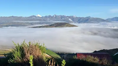 a view of a foggy valley with mountains in the background at Sky Dome Peru in Cusco