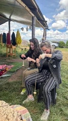 two women sitting under a tent playing a instrument at Sky Dome Peru in Cusco
