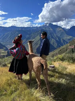 two people standing on a hill with a llama at Sky Dome Peru in Cusco