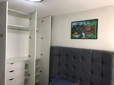 a bedroom with a couch and a painting on the wall at 595 Departamento en Chorrillos in Lima
