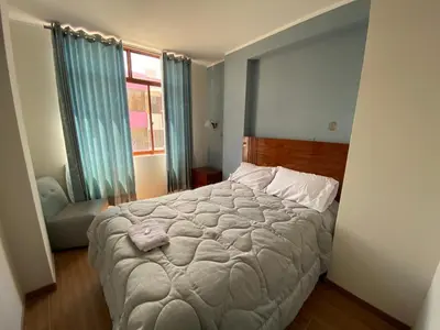 a bedroom with a large bed and a window at EL GRAN SEÑORIAL in Jauja
