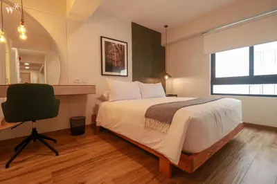 a bedroom with a bed and a desk and a chair at Colon by Wynwood House in Lima