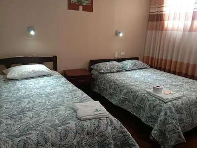 a hotel room with two beds with towels on them at Casa del Virrey Hospedaje in Jauja