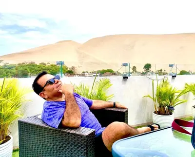 a man sitting in a chair with his hand to his face at Hotel Nebai in Ica