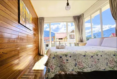 a bedroom with a bed and a large window at Colina Haus, casa vacacional Oxa in Oxapampa